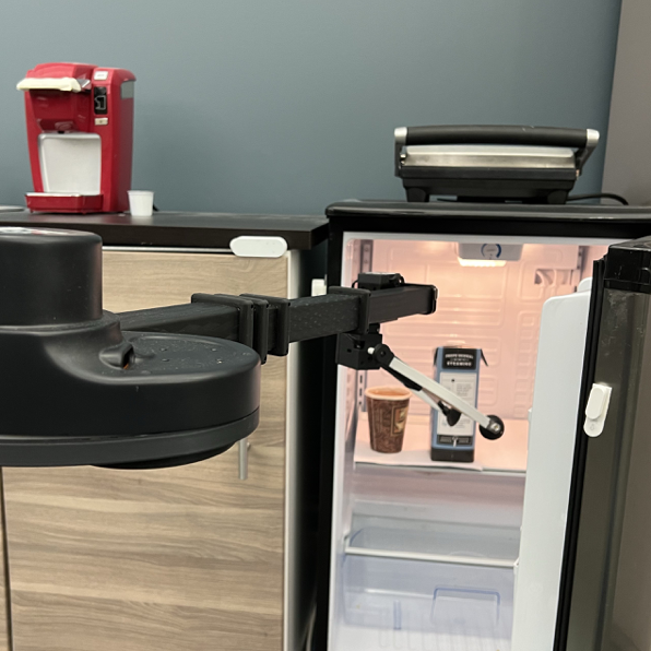 A Stretch robot reaching for milk in a fridge that also has a smart-home door sensor attached.